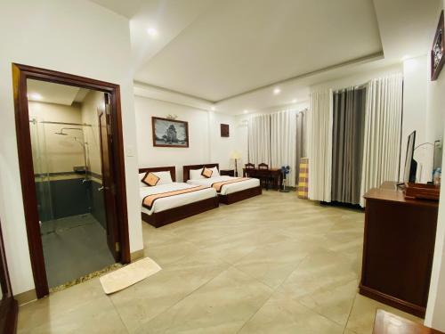 绥和市Jen Hotel的酒店客房设有两张床和淋浴。