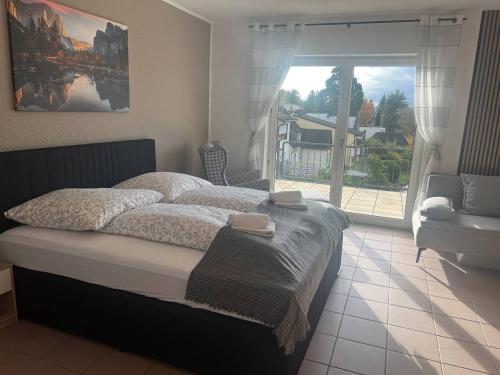 乌尔班Rheinview Sunset in Urbar的一间卧室设有一张大床和一个大窗户