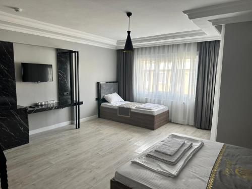 伊斯坦布尔Cevvo Hotel的一间卧室配有一张床,并在一间客房内配有电视。