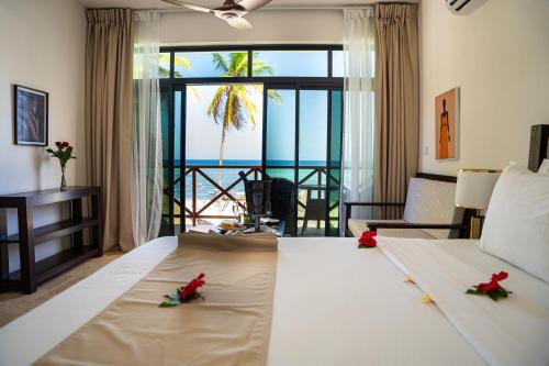 马特姆维Alladin Boutique Beach Hotel and SPA Zanzibar的一间卧室设有一张床,享有海景