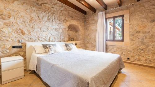 佩特拉Agroturismo son Calo的卧室配有一张石墙内的大床