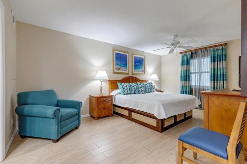 可可比奇The Resort on Cocoa Beach, a VRI resort的一间卧室配有一张床和一张蓝色椅子