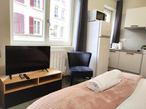 泰昂维Le LUX 11的一间卧室配有一张床、一台电视和一把椅子