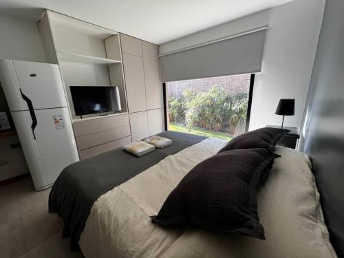 查克拉斯德科里亚The Owl Lodge Apart Studio N的卧室配有带枕头的大床和窗户。