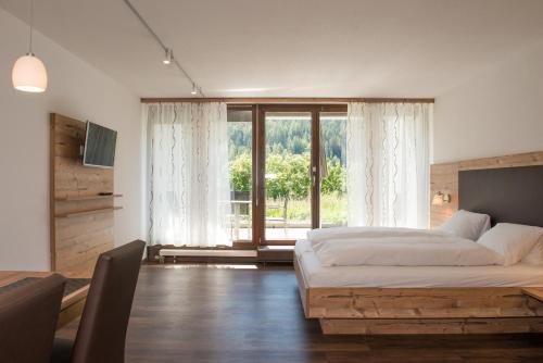 施库尔Ferienpark Tulai - Fam. Carl的一间卧室设有一张床和一个大窗户