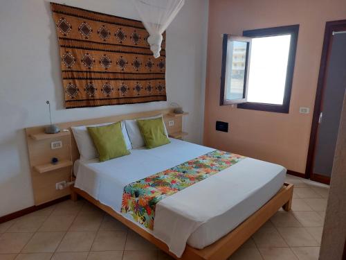 萨尔雷Ca Bonita的卧室配有带绿色枕头的大型白色床