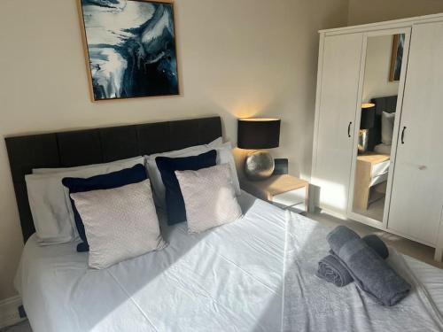 拉格斯Beautiful traditional flat in the center of Largs.的卧室配有带枕头和镜子的白色床