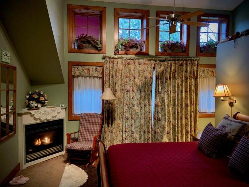 滨湖尼亚加拉威皮尼旅馆的一间卧室设有壁炉、一张床和一个壁炉