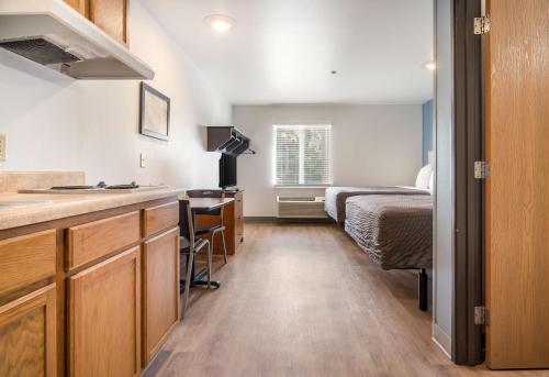 迈尔斯堡Extended Stay America Select Suites - Fort Myers的带厨房的房间和一间带一张床的卧室