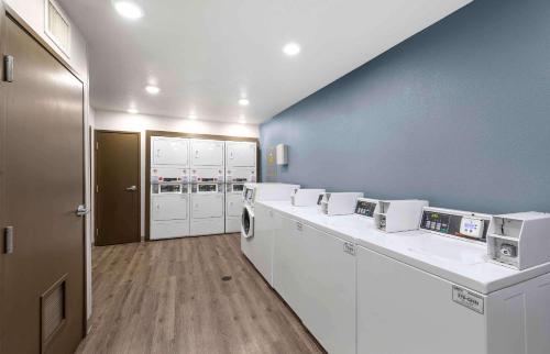 贝瑟默Extended Stay America Select Suites - Birmingham - Bessemer的洗衣房配有白色家电和蓝色墙壁