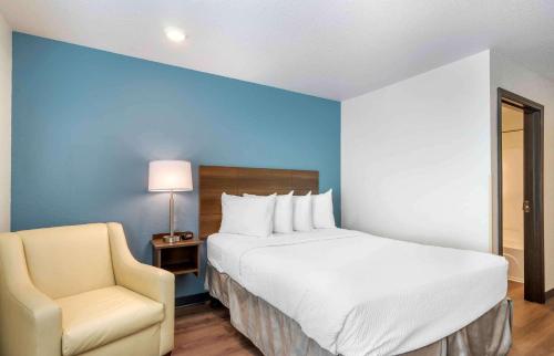 克利尔沃特Extended Stay America Suites - Clearwater的一间卧室配有一张大床和一把椅子