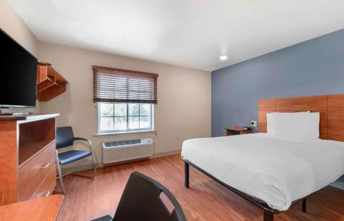 阿尔法利塔Extended Stay America Select Suites - Atlanta - Alpharetta的一间卧室配有一张大床和电视