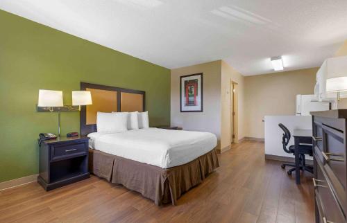哥伦比亚Extended Stay America Select Suites - Columbia - Ft Jackson的酒店客房配有一张床、一张书桌和一间厨房。