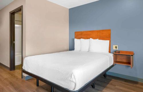 杰克逊维尔Extended Stay America Select Suites - Jacksonville - North的卧室配有白色的床和木制床头板
