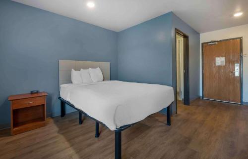 拉夫兰Extended Stay America Select Suites - Loveland的蓝色卧室设有一张床和木地板