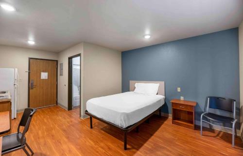 拉伯克Extended Stay America Select Suites - Lubbock - South的一间卧室设有一张床和蓝色的墙壁