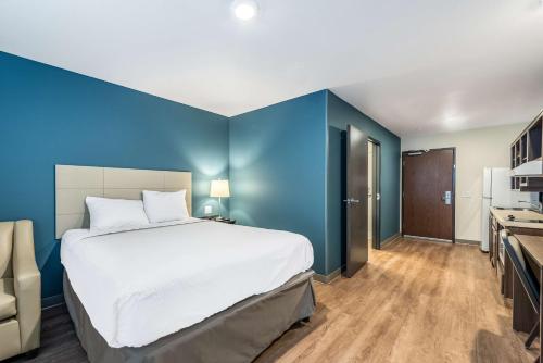 Mendota HeightsExtended Stay America Suites - Minneapolis - Airport - Mendota Heights的一间卧室设有一张大床和蓝色的墙壁