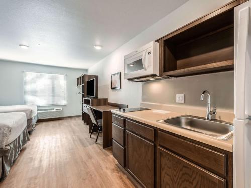 Mendota HeightsExtended Stay America Suites - Minneapolis - Airport - Mendota Heights的一个带水槽的厨房和一张位于客房内的床