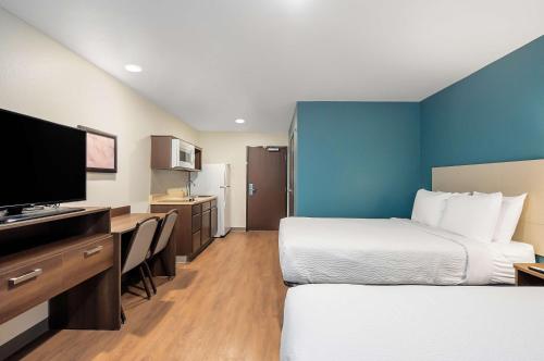 墨尔本Extended Stay America Select Suites - Melbourne - West Melbourne的酒店客房设有两张床和一台平面电视。