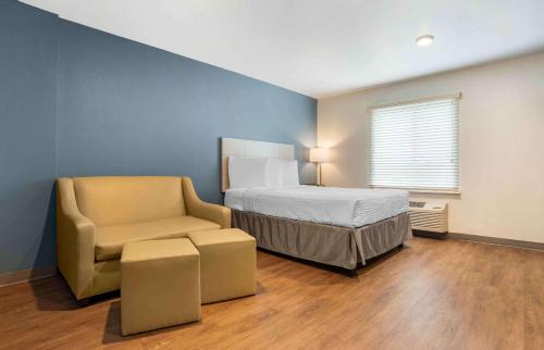 肯纳Extended Stay America Suites - New Orleans - Airport - I-10的一间卧室,卧室内配有一张床和一把椅子