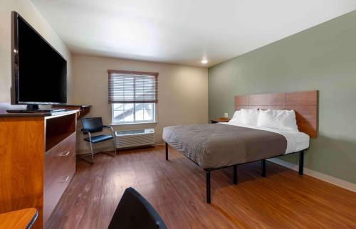 俄克拉何马城Extended Stay America Select Suites - Oklahoma City - West的配有一张床和一台平面电视的酒店客房