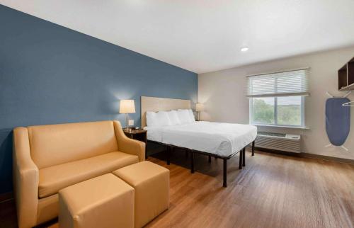 伍德伯里Extended Stay America Suites - St Paul - Woodbury的一间卧室配有一张床、一张沙发和一把椅子
