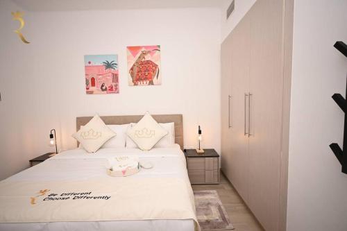 阿布扎比Charming Rossa 1BR Getaway Yas Island的一间卧室配有一张带白色床单的大床