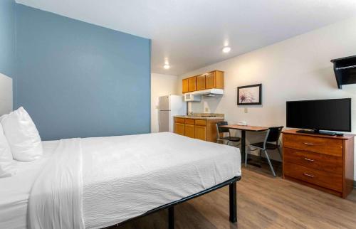 埃尔帕索Extended Stay America Select Suites - El Paso - East的酒店客房配有一张床和一张书桌及一台电视