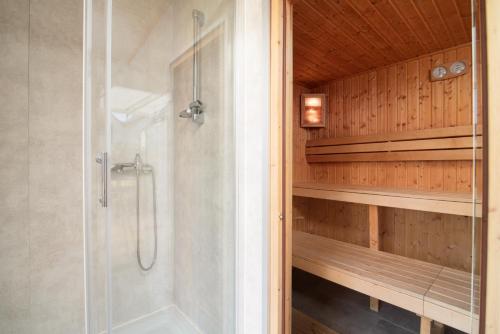 德布吉Fantazja&spa的设有带木墙的浴室内的步入式淋浴间