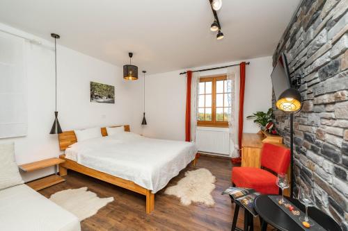普利特维采湖B&B Villa Sumrak Plitvica Rooms的一间卧室设有一张床和砖墙