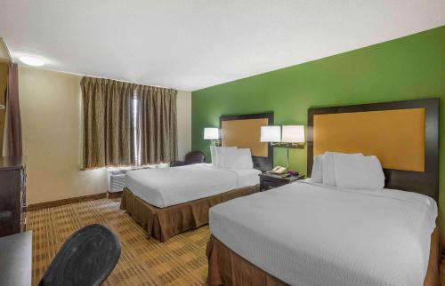 霍舍姆美国费城霍舍姆威尔士路长住酒店的一间酒店客房,设有两张床和绿色的墙壁