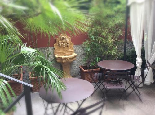 米兰Hotel Colombia的花园内带两张桌子和雕像的庭院