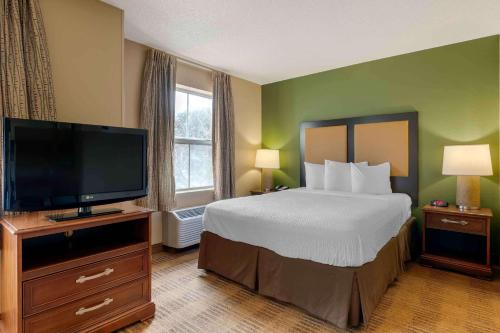 奥兰多美国长住酒店 - 奥兰多会议中心6443维斯特伍德的配有一张床和一台平面电视的酒店客房