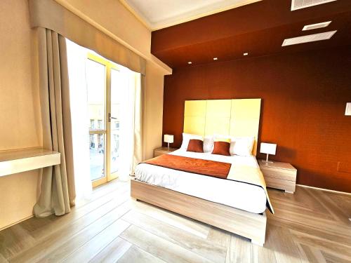 莱切Trilogy Prestige - Central Premium Suites的一间卧室设有一张床和一个大窗户