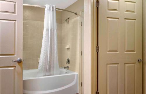 坦帕美国延住酒店 - 坦帕 - 机场 - 北西岸大道的带浴缸和白色淋浴帘的浴室