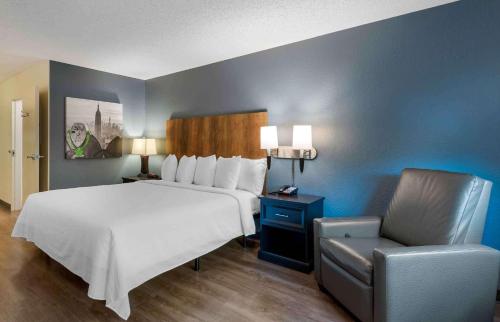 迈阿密Extended Stay America Premier Suites - Miami - Coral Gables的一间卧室配有一张大床和一把椅子