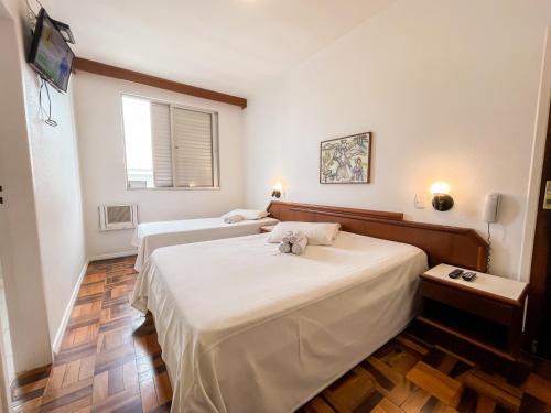 弗洛里亚诺波利斯Canas Gold Praia Hotel的一间卧室配有两张床和电视。