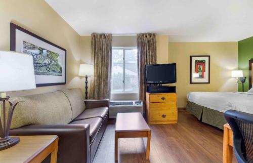 沃尔瑟姆美国波士顿沃尔瑟姆第四大道32号长住酒店的酒店客房设有沙发、床和电视。