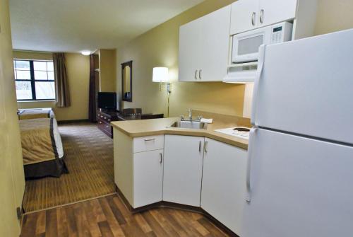 曼彻斯特Extended Stay America Select Suites - Hartford - Manchester的一间带白色冰箱的厨房和一间房间