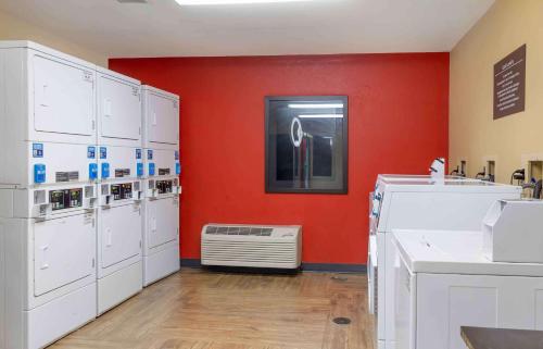 沃里克美国长住酒店 - 普罗维登斯 - 沃里克的洗衣房配有白色的洗涤器和红色的墙壁