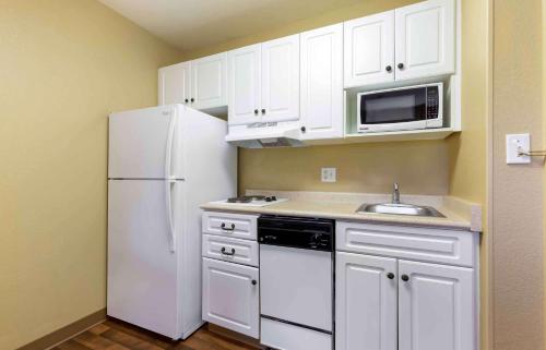 费尔法克斯阿美莉卡华盛顿特区费尔法克斯长住酒店的厨房配有白色橱柜和白色冰箱。