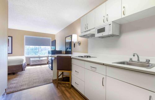 泰森斯角美国长住酒店 - 华盛顿特区 - 泰森斯角的厨房配有白色橱柜、水槽和床。