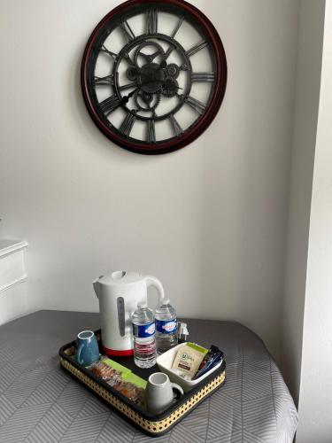AudervilleLa petite Irlande的一个带咖啡壶的托盘和墙上的时钟