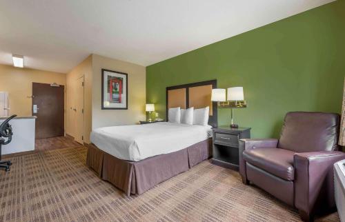布卢明顿布鲁明顿美洲长住酒店的配有一张床和一把椅子的酒店客房