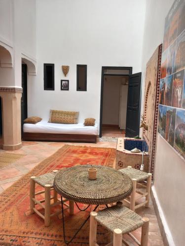 马拉喀什Riad Hostel JAD ZIAD的配有桌椅和床的房间