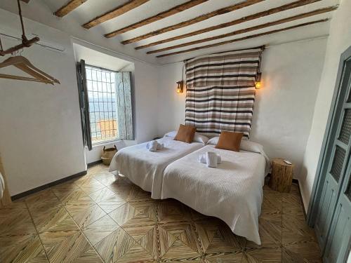 IznatorafAlojamiento Manzanilla的一间卧室设有一张床和两个窗户。
