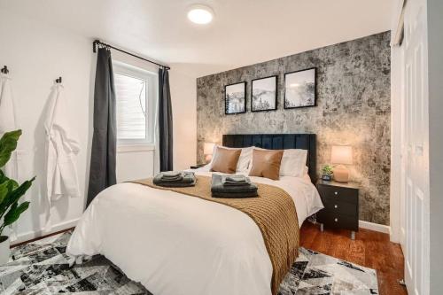 丹佛Adorable 2-Bedroom Modern Basement的一间卧室设有一张大床和砖墙