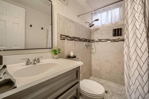 丹佛Adorable 2-Bedroom Modern Basement的白色的浴室设有水槽和卫生间。