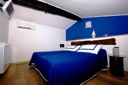 蒙特罗索阿尔马雷阿菲塔卡梅雷达切萨雷酒店的蓝色和白色的卧室,配有蓝色的床