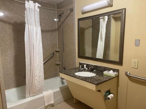 亚特兰大Budgetel Inn & Suites Atlanta的一间带水槽、浴缸和淋浴的浴室